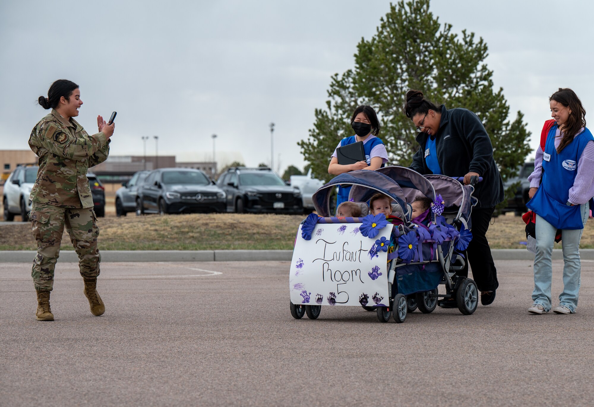 Children in a stroller being photographed by a military mother