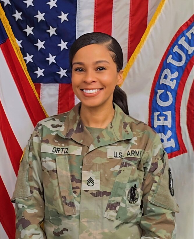 Female U.S. Army Soldier posing in front of the U.S. Army flag and USAREC flag