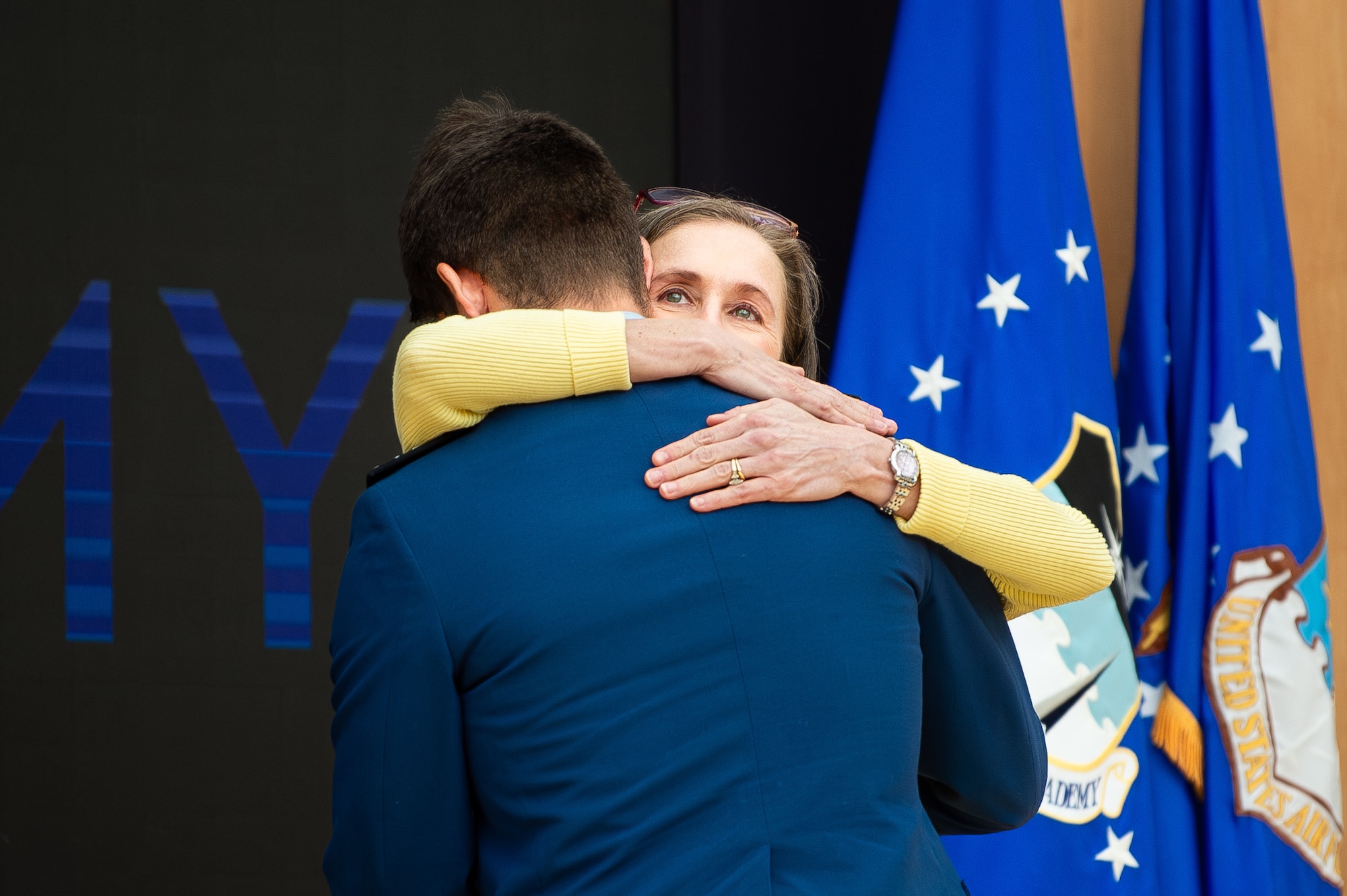 Mrs. Alicia Shamblin, a registered nurse and military spouse, embraces Cadet 3rd Class Boaz Abramoff during an award ceremony at Polaris Hall, March 31, 2025. Shamblin was recognized for her swift response and medical expertise that saved Abramoff’s life following a parachuting accident on July 31, 2023. (U.S. Air Force photo by Dylan Smith)