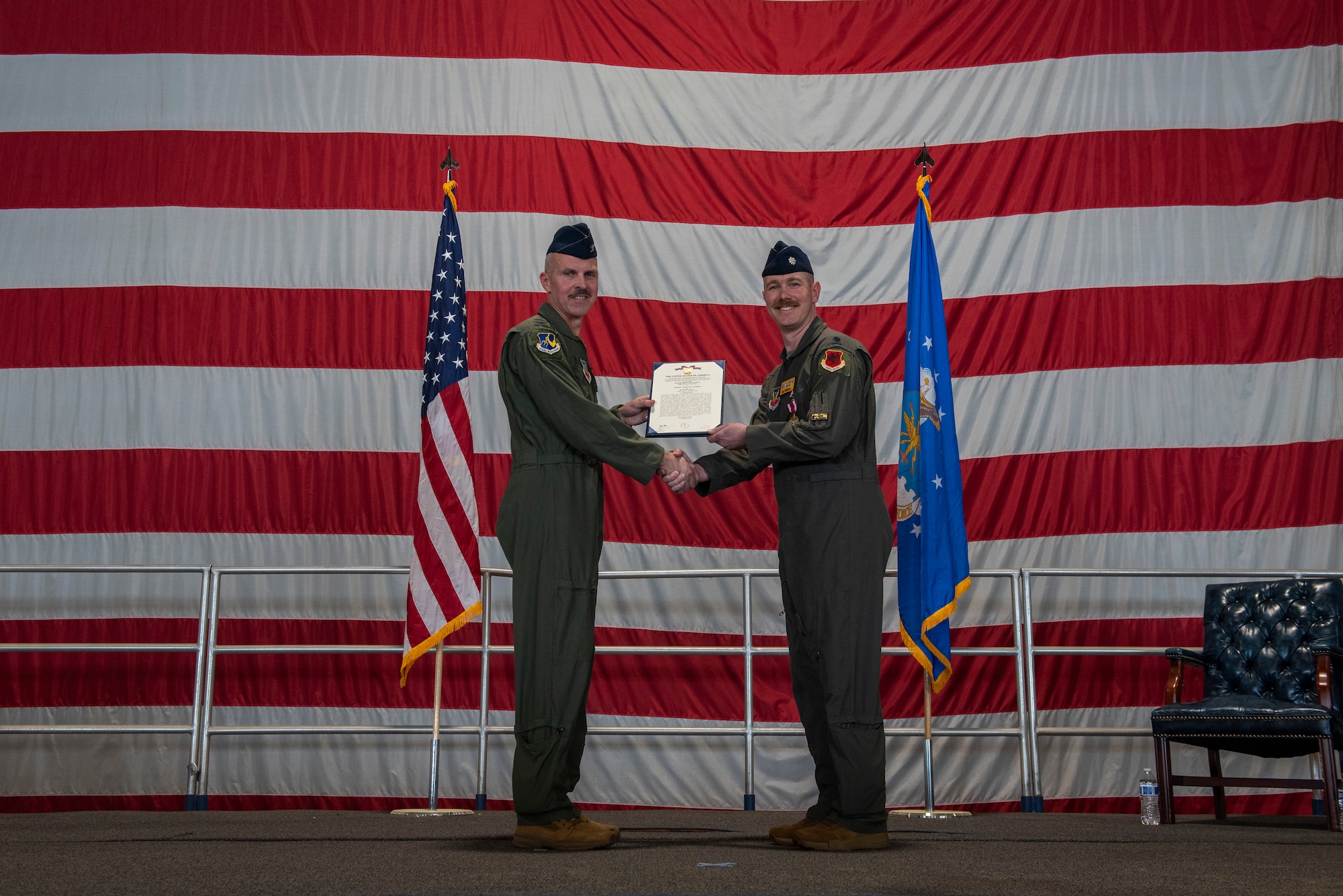 U.S. Air Force Col. Trevor Merrell, 25th Attack Group commander, presents a meritorious service medal to Lt. Col. Chad Swinehart, 482nd Attack Squadron outgoing commander, during the 482 ATKS change of command ceremony at Shaw Air Force Base, S.C., Mar. 28, 2025.