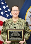 t. Cmdr. Devon Johnston, Military Program Director for NMCCL’s Combined Military-Civilian Psychiatry Residency Program poses with the Victor J. Teichnor plaque.