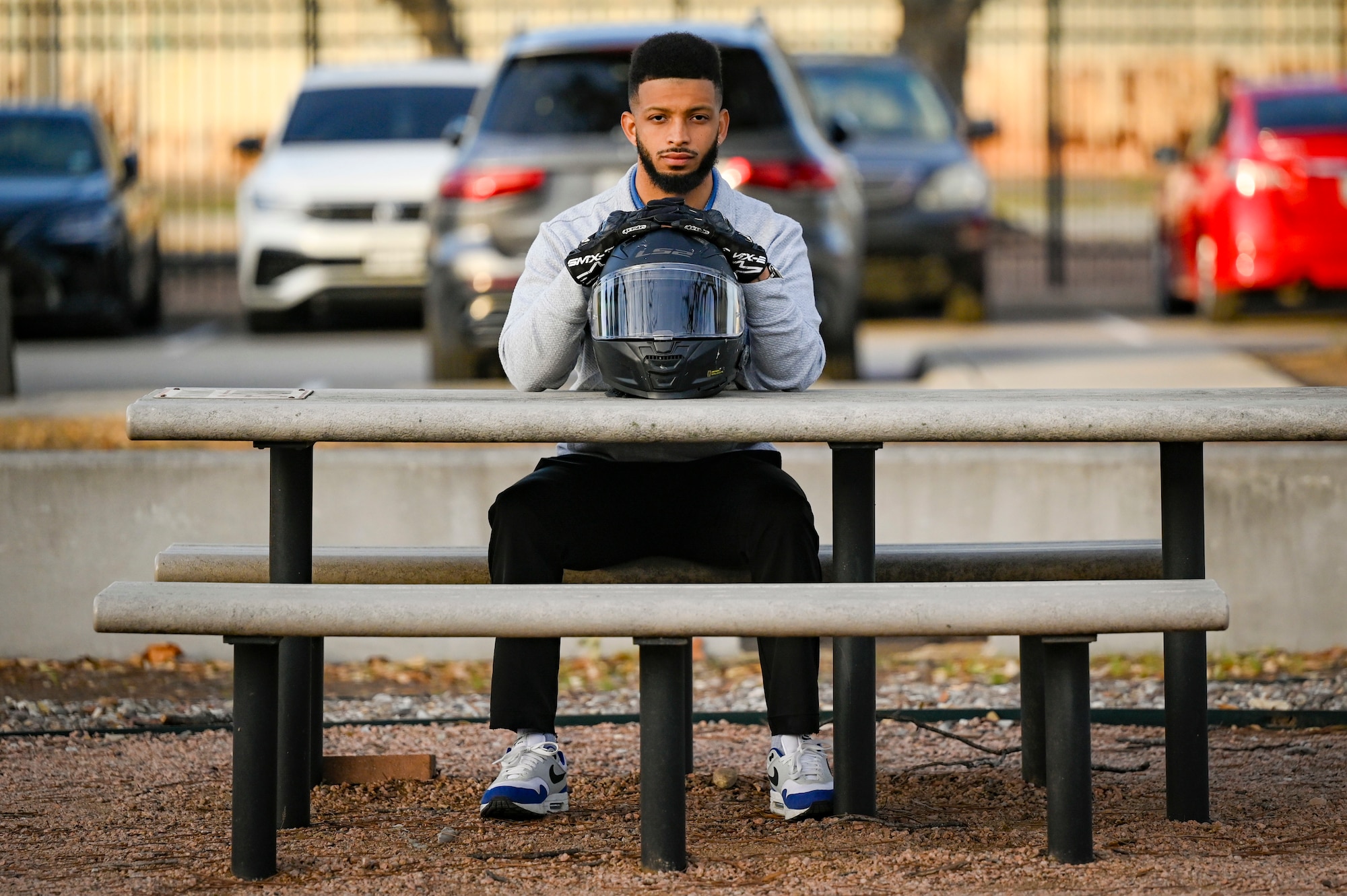 Collin Cox sitting on a bench with his helmet.