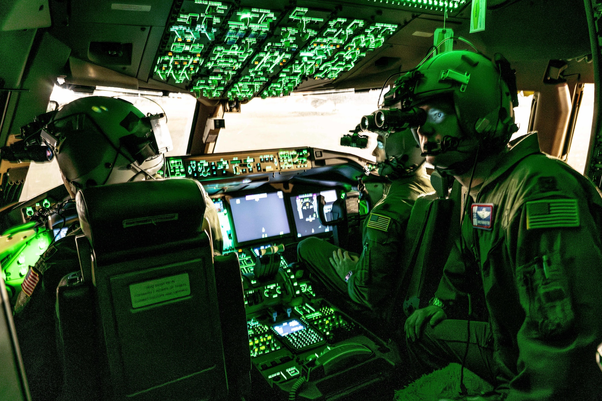 Airmen sitting in cockpit of aircraft.