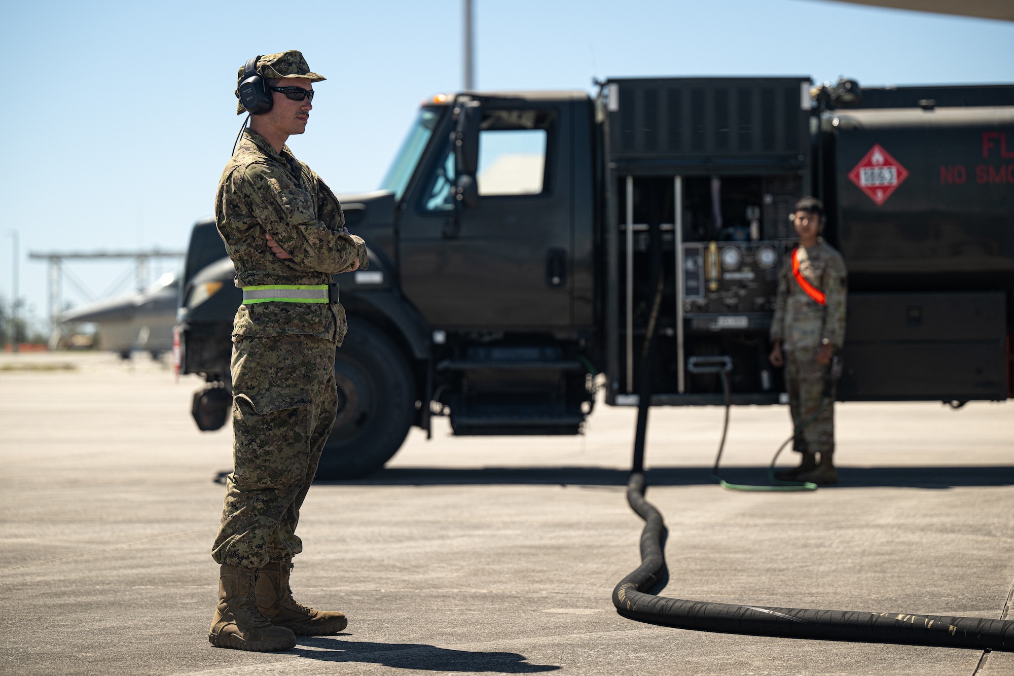 Two members watch during an aircraft refuling