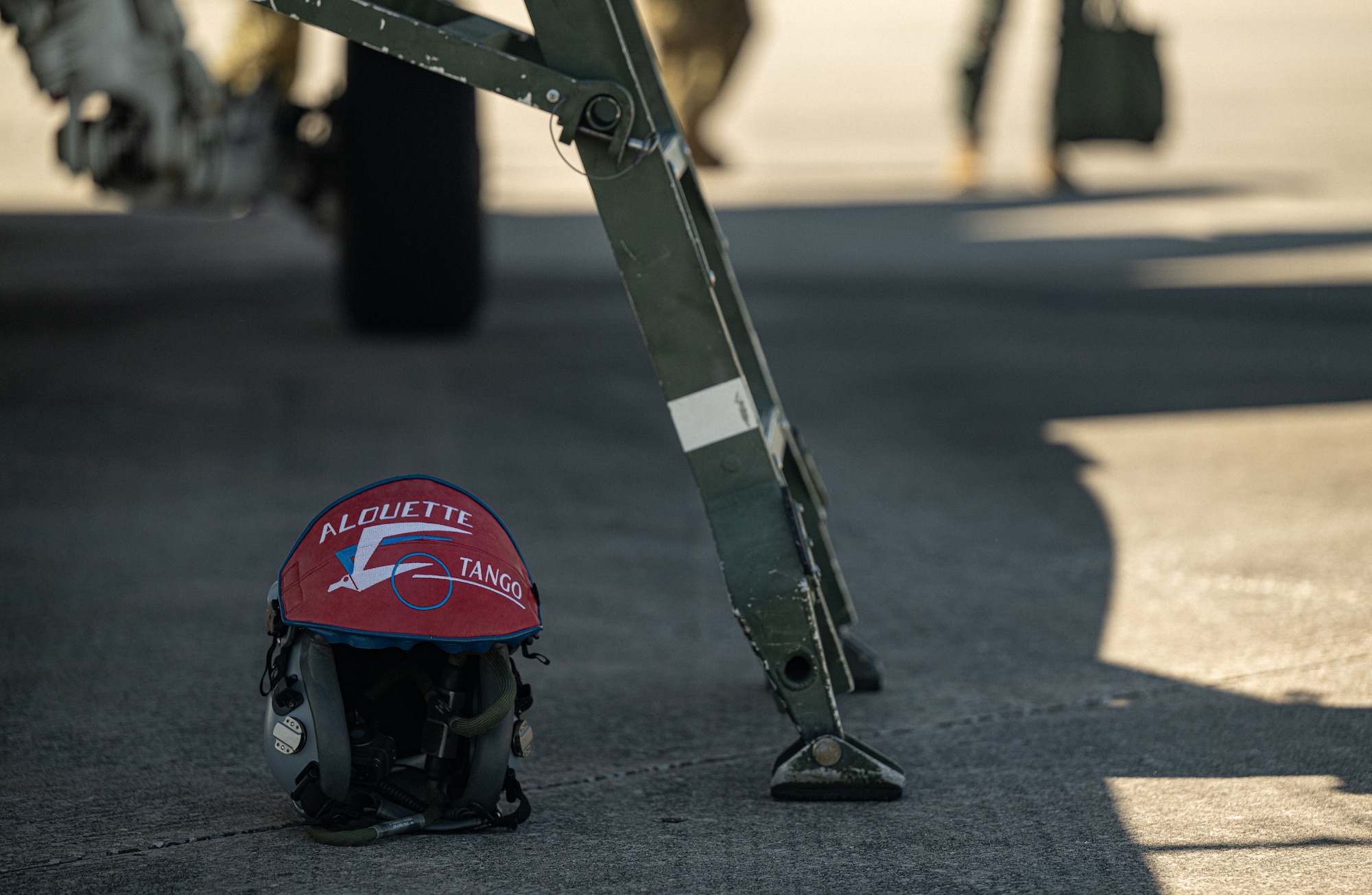 A pilots helmet rests on the ground before flight