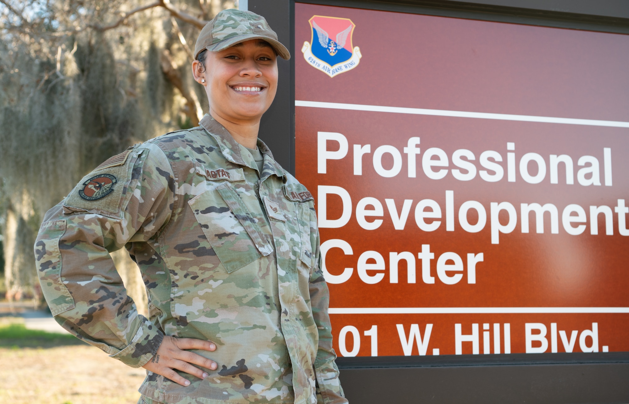 African American female U.S. Air Force Staff Sgt., standing in front of Professional Development center sign.