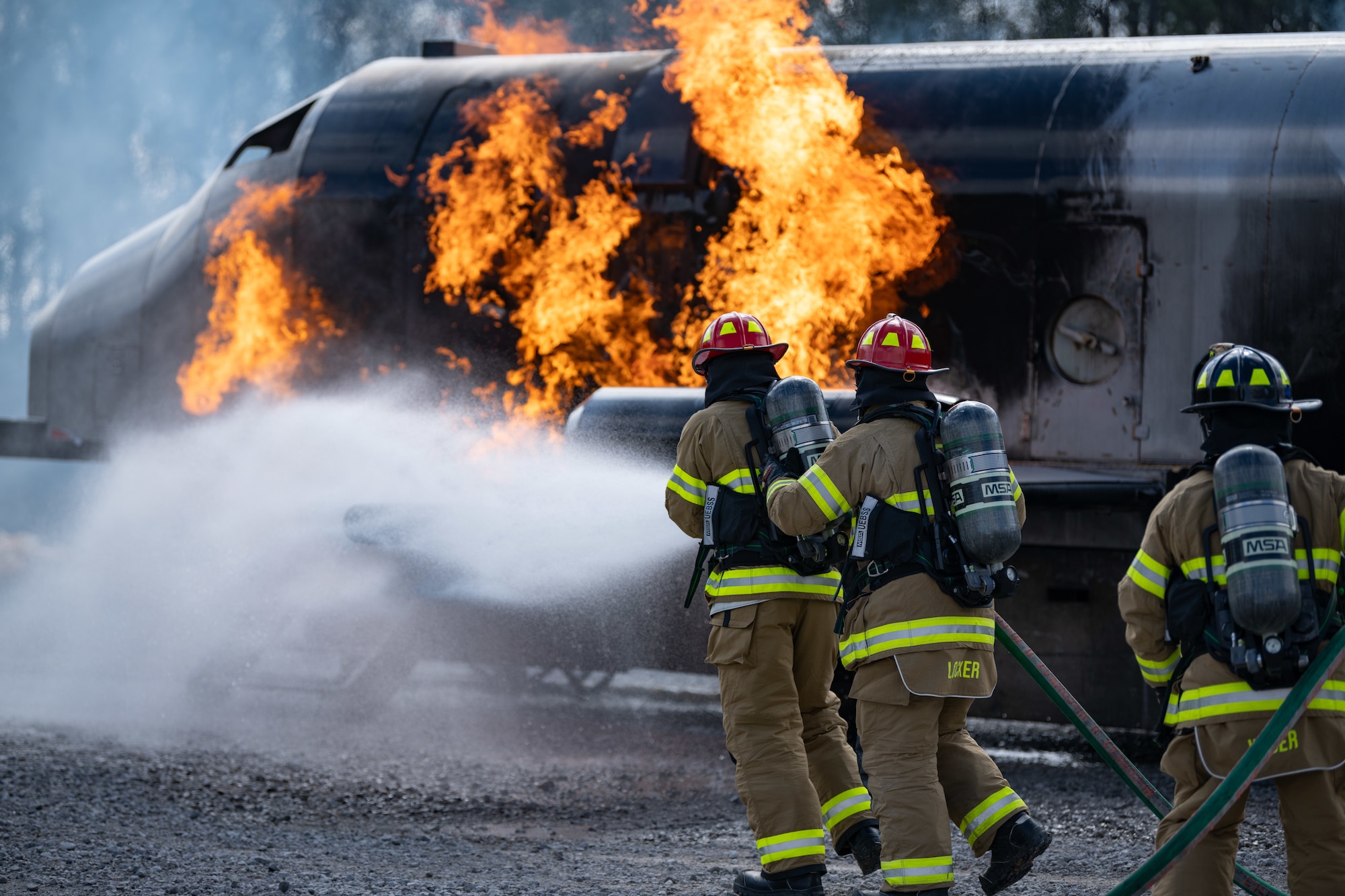 Arnold Engineering Development Complex Commander Col. Grant Mizell, left, attempts to extinguish a simulated aircraft fire during live fire training March 6, 2025, at Arnold Air Force Base, Tenn. Mizell is supported by Arnold AFB Fire and Emergency Services Firefighter Crew Chief Kenneth Locker and firefighter Justin Wiser. AEDC is headquartered at Arnold AFB. In early March, Arnold FES conducted live fire training exercises on the base to maintain compliance and enhance emergency response readiness. Training sessions involved the use of a mobile trailer to simulate a residential structure fire and a simulator to emulate interior and exterior aircraft fuselage fires. (U.S. Air Force photo by Keith Thornburgh)