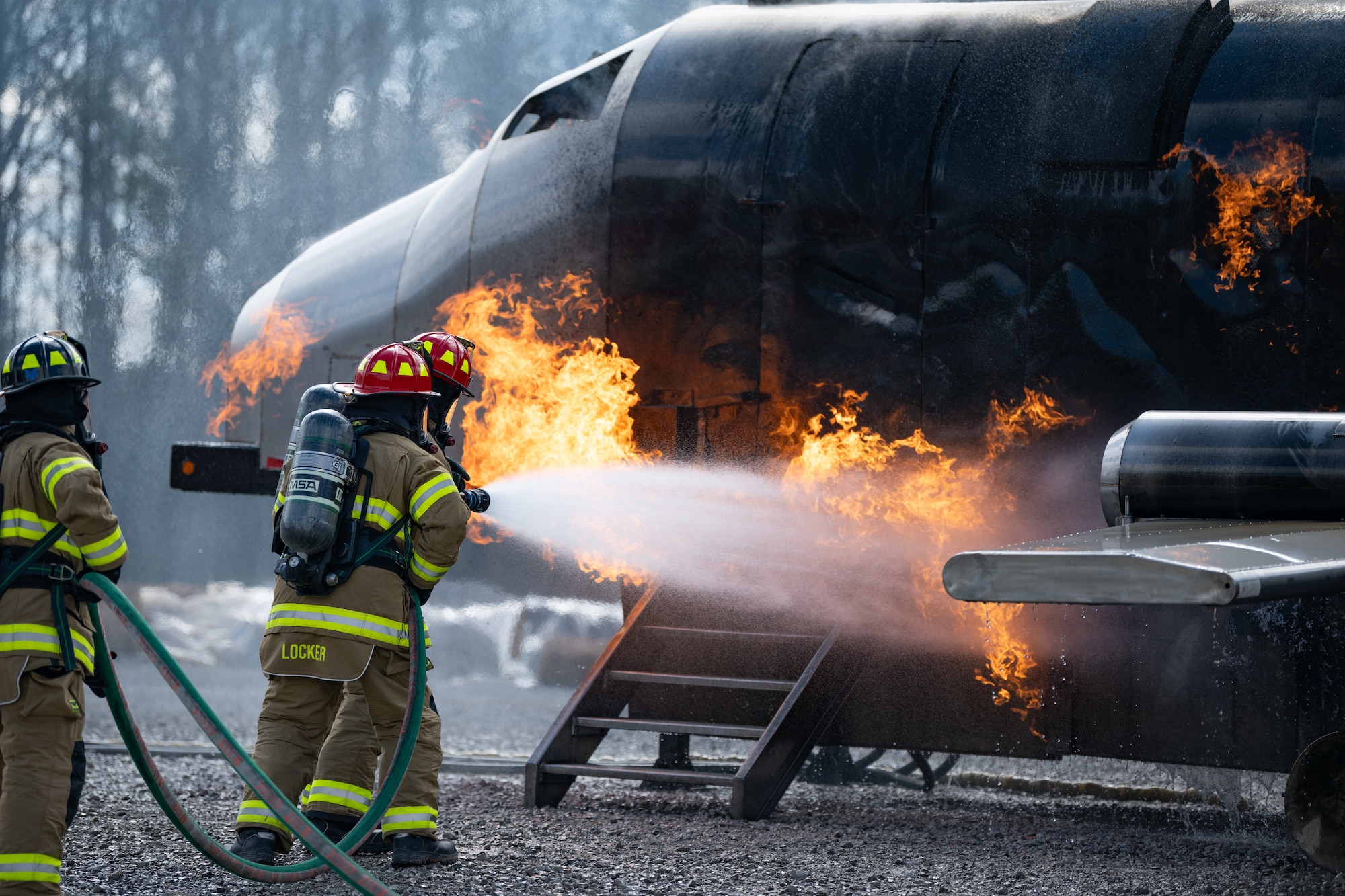 Arnold Engineering Development Complex Commander Col. Grant Mizell, left, attempts to extinguish a simulated aircraft fire during live fire training March 6, 2025, at Arnold Air Force Base, Tenn. Mizell is supported by Arnold AFB Fire and Emergency Services Firefighter Crew Chief Kenneth Locker. AEDC is headquartered at Arnold AFB. In early March, Arnold FES conducted live fire training exercises on the base to maintain compliance and enhance emergency response readiness. Training sessions involved the use of a mobile trailer to simulate a residential structure fire and a simulator to emulate interior and exterior aircraft fuselage fires. (U.S. Air Force photo by Keith Thornburgh)