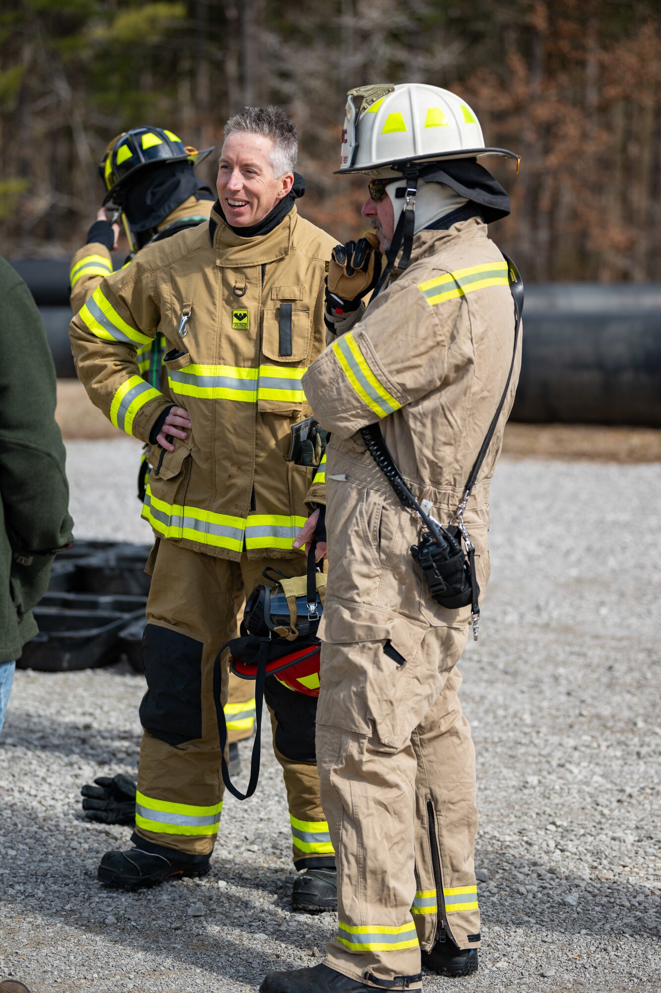 Arnold Engineering Development Complex Commander Col. Grant Mizell, left, discusses his experience participating in live fire training with Arnold Air Force Base Fire and Emergency Services Assistant Chief Gary Horn March 6, 2025, at Arnold AFB, Tenn. AEDC is headquartered at Arnold AFB. In early March, Arnold FES conducted live fire training exercises on the base to maintain compliance and enhance emergency response readiness. Training sessions involved the use of a mobile trailer to simulate a residential structure fire and a simulator to emulate interior and exterior aircraft fuselage fires. (U.S. Air Force photo by Keith Thornburgh)