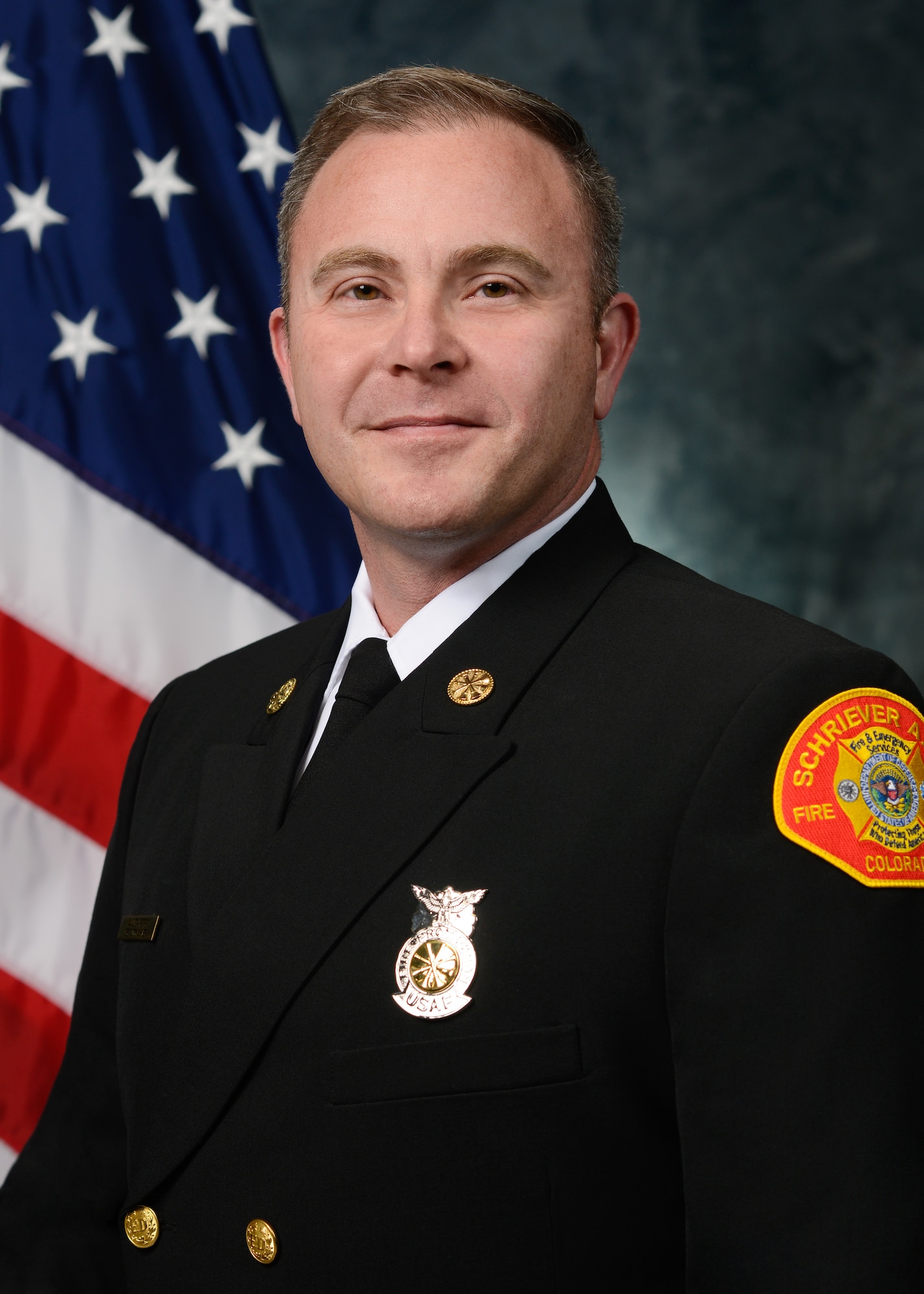 Fire Department member posing for official photo with U.S. flag