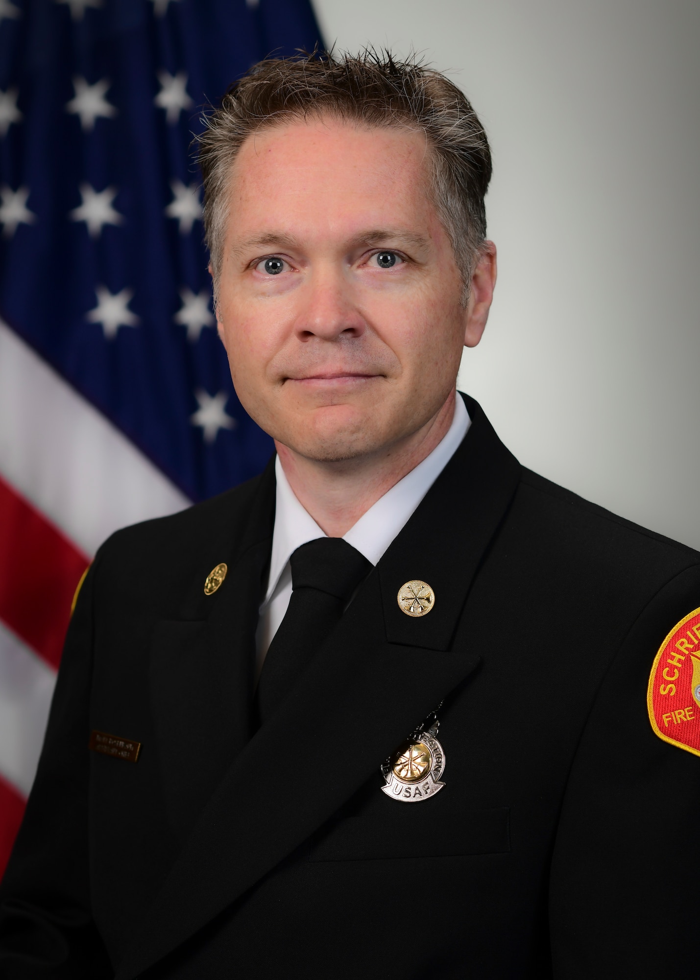 Fire Department member posing for official photo with U.S. flag