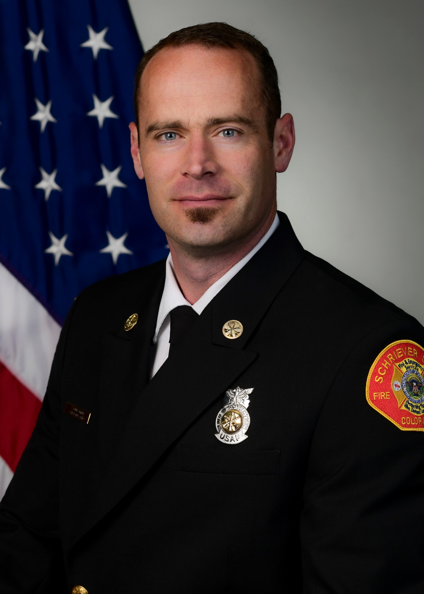 Fire Department member posing for official photo with U.S. flag