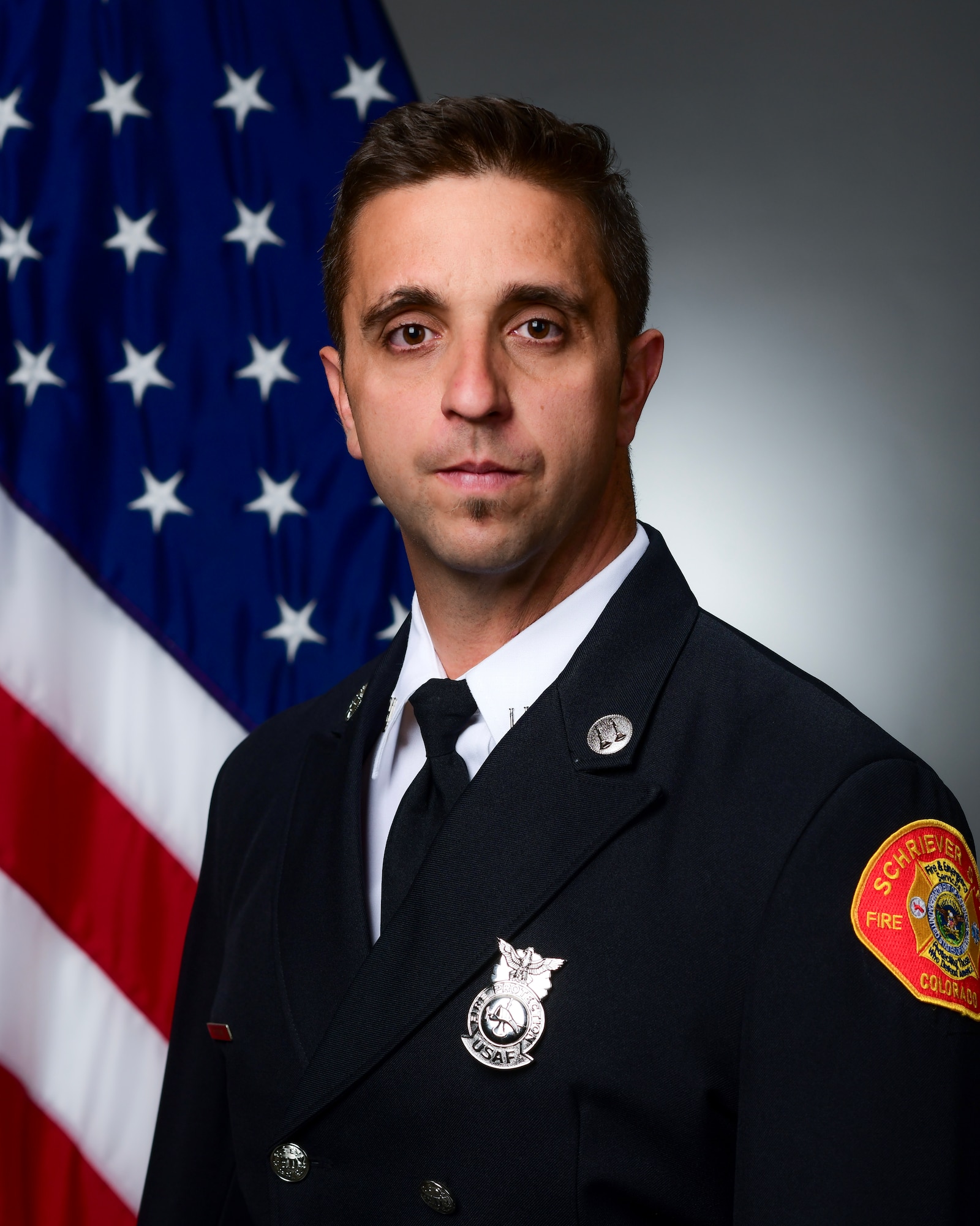 Fire Department member posing for official photo with U.S. flag