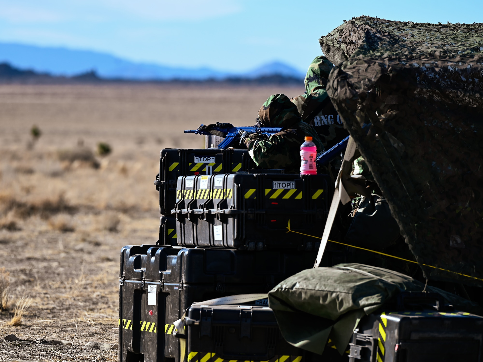 Airmen monitor the perimeter from a camouflaged observation point. The task was part of Exercise Bamboo Eagle at the Nevada Test and Training Range, Feb. 4, 2025.