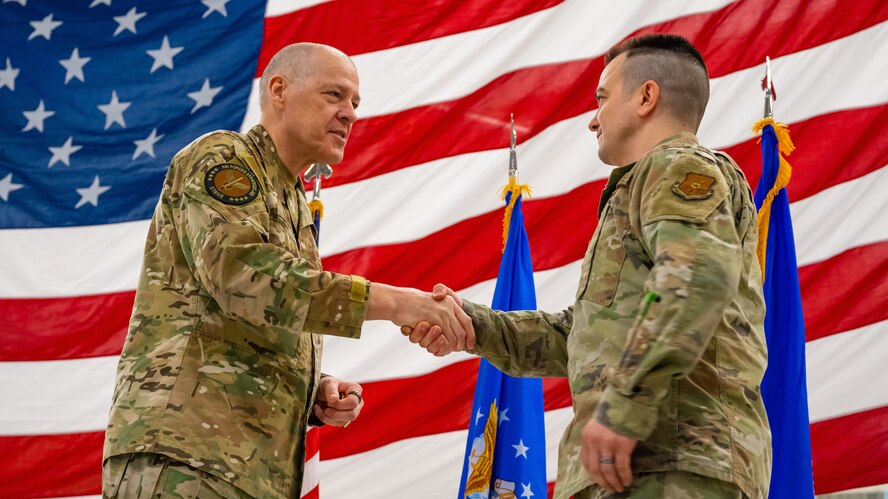 U.S. Air Force Gen. Thomas Bussiere coins an Airman during an all-call.