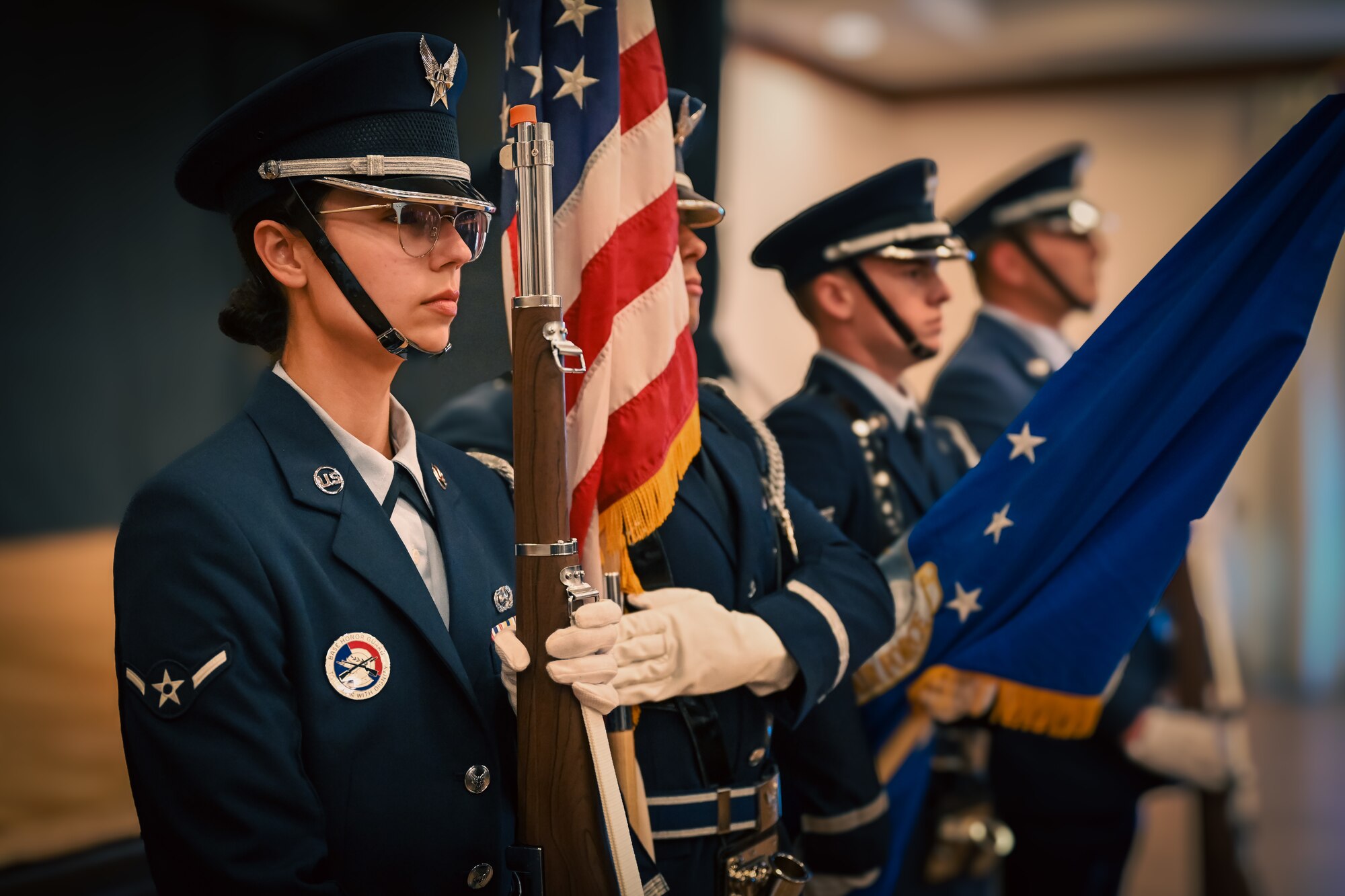 Servicemembers lines up holding flags and rifles