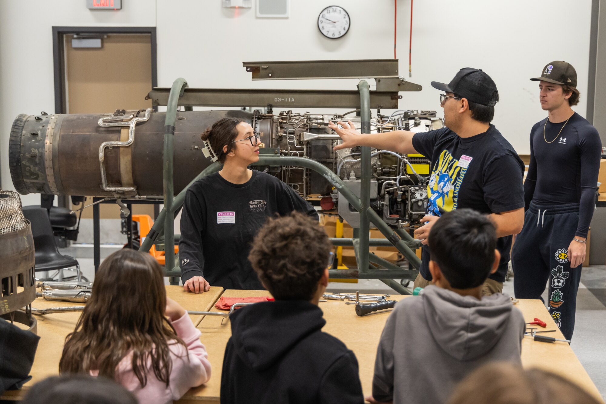 STARBASE students visit a class called Advanced Aircraft Maintenance Technology at the Desert High School Aerospace Lab on Edwards Air Force Base, California. Two alumns of Muroc School District and currently employees at the 412th Test Wing, Savannah Wilson and Kevin Koper, describe how jet engines work to the visiting students.
