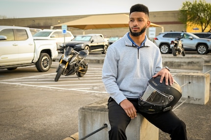 Collin Cox poses with his helmet for a photograph.