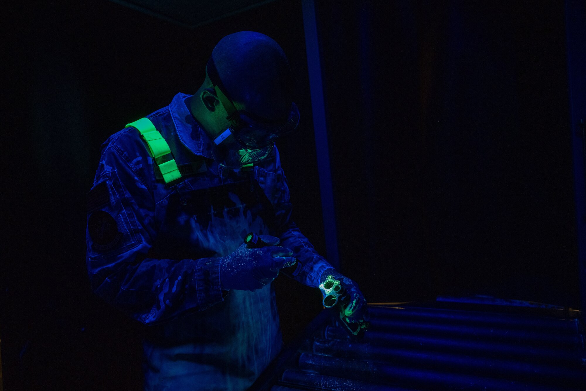Master Sgt. Jason Barker, 931st Maintenance Squadron nondestructive inspection section chief, inspects a KC-135 Stratotanker part April 1, 2025, at McConnell Air Force Base, Kansas. NDI specialists use the penetrant liquid inspection method to detect defects in small aircraft parts, ensuring the parts’ structural integrity and ultimately protecting the lives of pilots and air crew. (U.S. Air Force photo by Airman 1st Class Paula Arce)