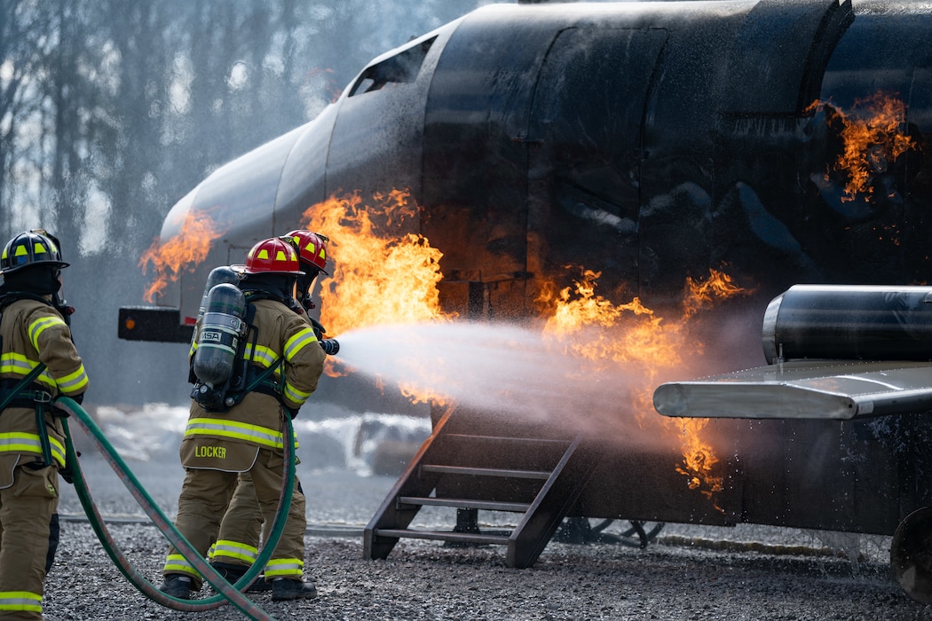 Arnold Engineering Development Complex Commander Col. Grant Mizell, left, attempts to extinguish a simulated aircraft fire during live fire training March 6, 2025, at Arnold Air Force Base, Tenn. Mizell is supported by Arnold AFB Fire and Emergency Services Firefighter Crew Chief Kenneth Locker. AEDC is headquartered at Arnold AFB. In early March, Arnold FES conducted live fire training exercises on the base to maintain compliance and enhance emergency response readiness. Training sessions involved the use of a mobile trailer to simulate a residential structure fire and a simulator to emulate interior and exterior aircraft fuselage fires. (U.S. Air Force photo by Keith Thornburgh)
