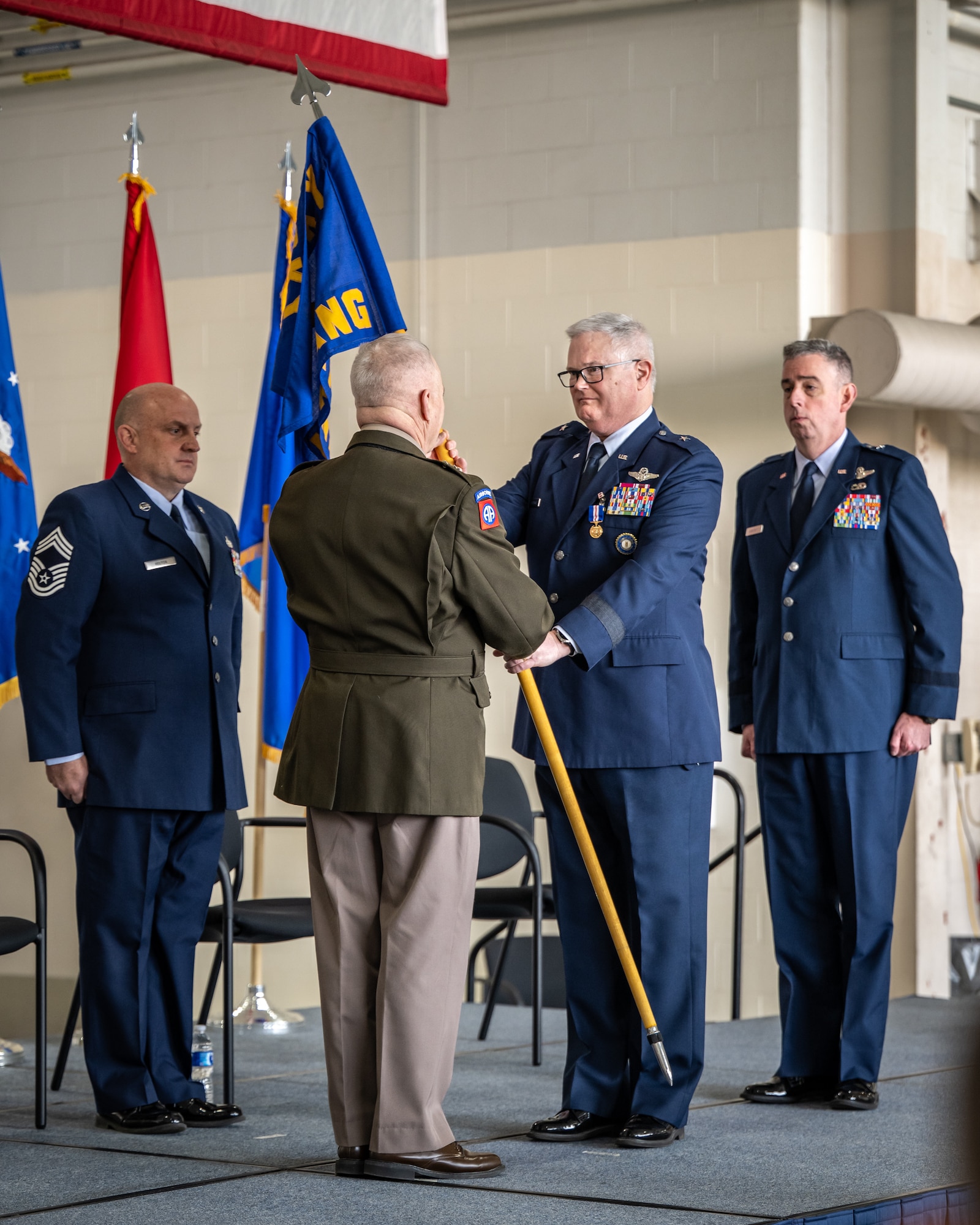 U.S. Air Force Brig. Gen. David Mounkes, right, Kentucky’s outgoing assistant adjutant general for Air, relinquishes command of the Kentucky Air National Guard by handing the organization’s guidon to U.S. Army Maj. Gen. Haldane Lamberton, adjutant general of the Commonwealth of Kentucky, during a ceremony at the Kentucky Air National Guard Base in Louisville, Ky., March 14, 2025. Mounkes is stepping down from the post to retire from military service, ending a 35-year career in the active-duty Air Force and Air National Guard. (U.S. Air National Guard photo by Dale Greer)