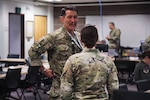 Col. Matthew Komatsu, director of Plans and Strategy for the Joint Staff, Alaska National Guard, discusses the role of Women, Peace, and Security during mission planning with Maj. Chelsea Aspelund, State Partnership Program director, Alaska National Guard, at Joint Base Elmendorf-Richardson, Alaska, March 6, 2025. Exercise Vigilant Guard is a Full-Scale Exercise designed to ensure effective coordination between local, state, private sector, non-governmental organizations, and federal partners.