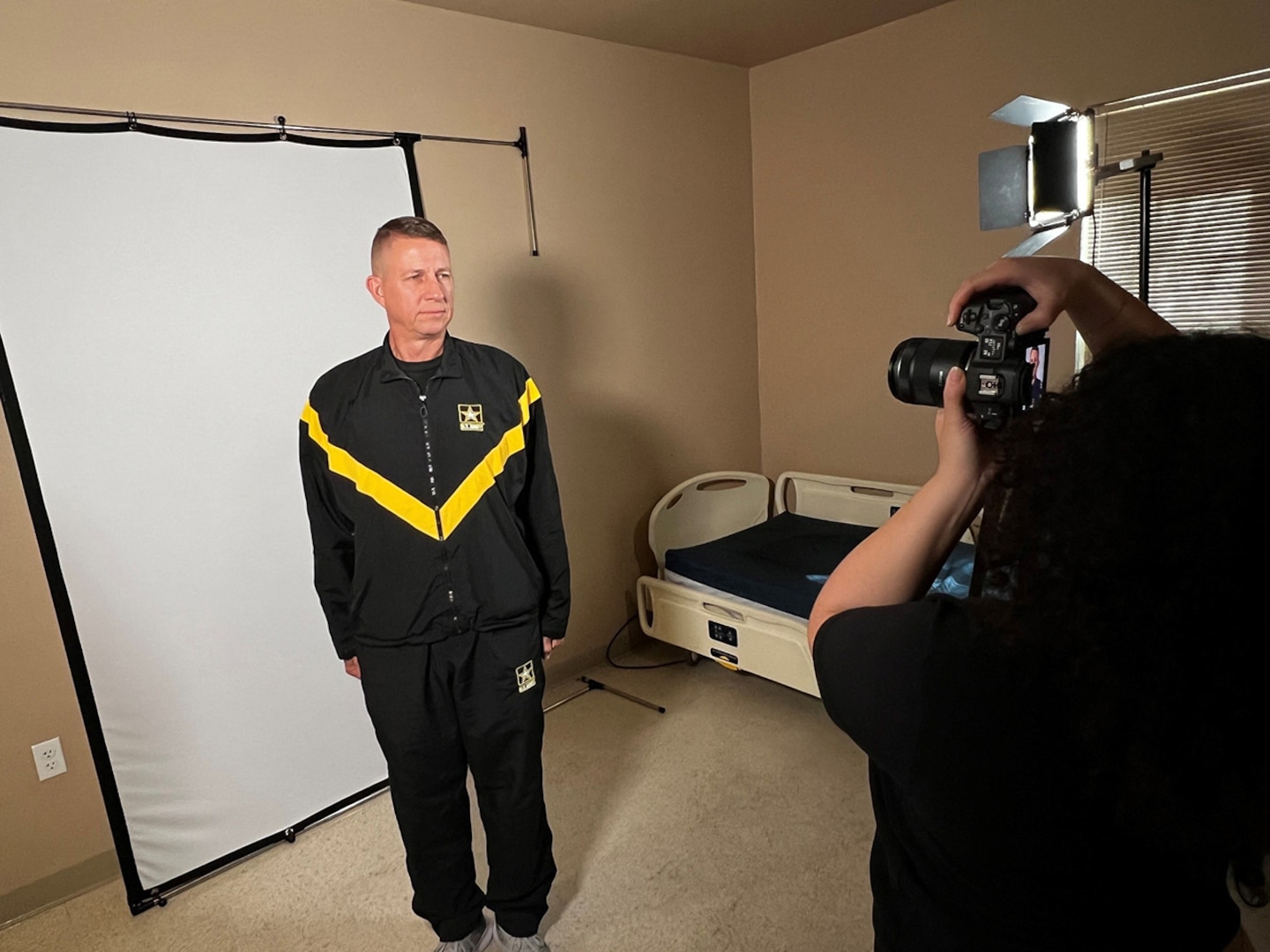 Lt. Col. John Hutka gets his bio book headshot taken by U.S. Army Spc. Kamisha Jordan with the 55th Public Affairs Company.