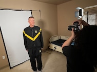 Lt. Col. John Hutka gets his bio book headshot taken by U.S. Army Spc. Kamisha Jordan with the 55th Public Affairs Company.