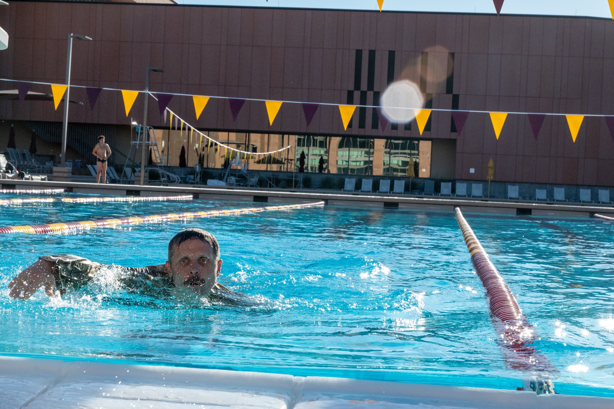 A military member swims in a pool.