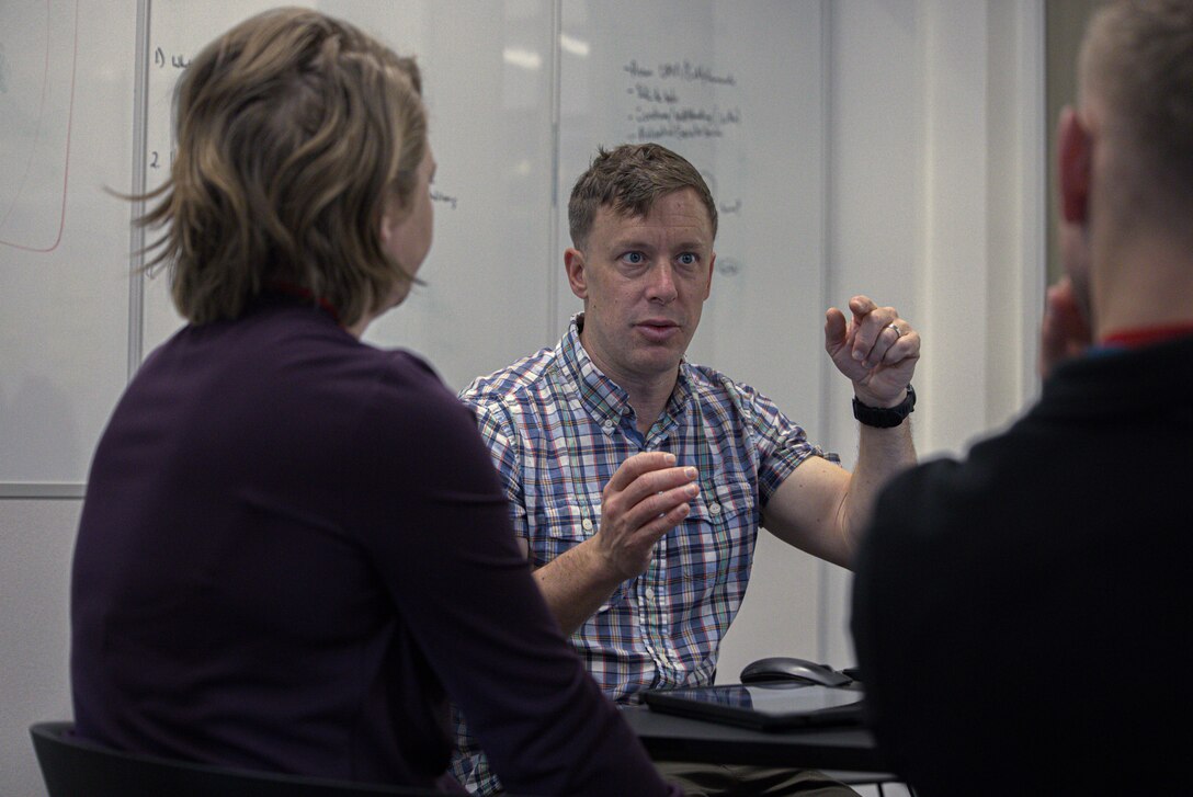 U.S. Marine Corps Major David McGee, assigned to the Marine Innovation Unit (MIU), Marine Forces Reserve, discusses the development of the Augmented Reconnaissance and Estimate of the Situation (ARES) software at the Marine Corps Software Factory (MCSWF) in Austin, Texas, 17 - 29 March, 2025.  MIU Marines are assisting MCSWF in the development and production of software solutions that address critical needs for the Marine Corps, including an update to ARES that predicts helicopter landing zones based on topographical data. MIU is a Selected Marine Corps Reserve unit headquartered in Newburgh, N.Y. that accelerates the development and adoption of advanced capabilities across the Marine Corps. (U.S. Marine Corps photo by Cpl. Orion Stpierre)