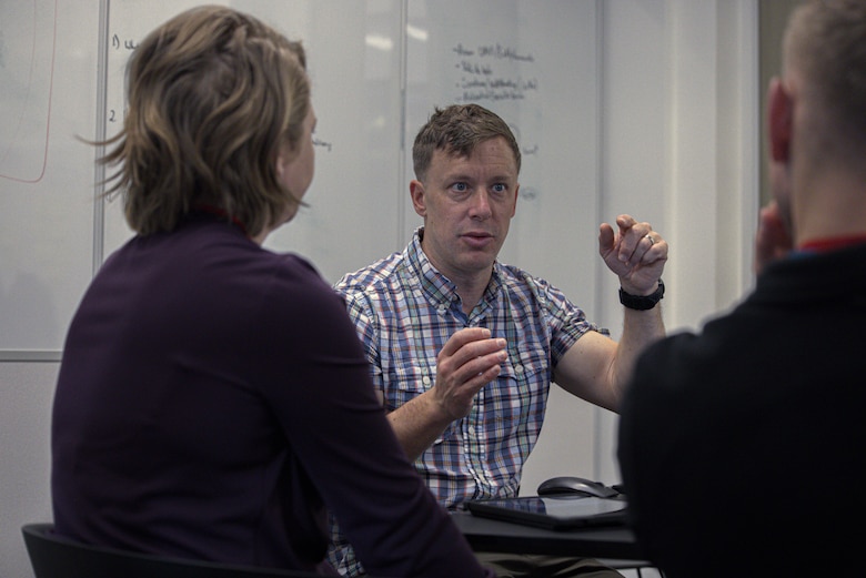 U.S. Marine Corps Major David McGee, assigned to the Marine Innovation Unit (MIU), Marine Forces Reserve, discusses the development of the Augmented Reconnaissance and Estimate of the Situation (ARES) software at the Marine Corps Software Factory (MCSWF) in Austin, Texas, 17 - 29 March, 2025.  MIU Marines are assisting MCSWF in the development and production of software solutions that address critical needs for the Marine Corps, including an update to ARES that predicts helicopter landing zones based on topographical data. MIU is a Selected Marine Corps Reserve unit headquartered in Newburgh, N.Y. that accelerates the development and adoption of advanced capabilities across the Marine Corps. (U.S. Marine Corps photo by Cpl. Orion Stpierre)
