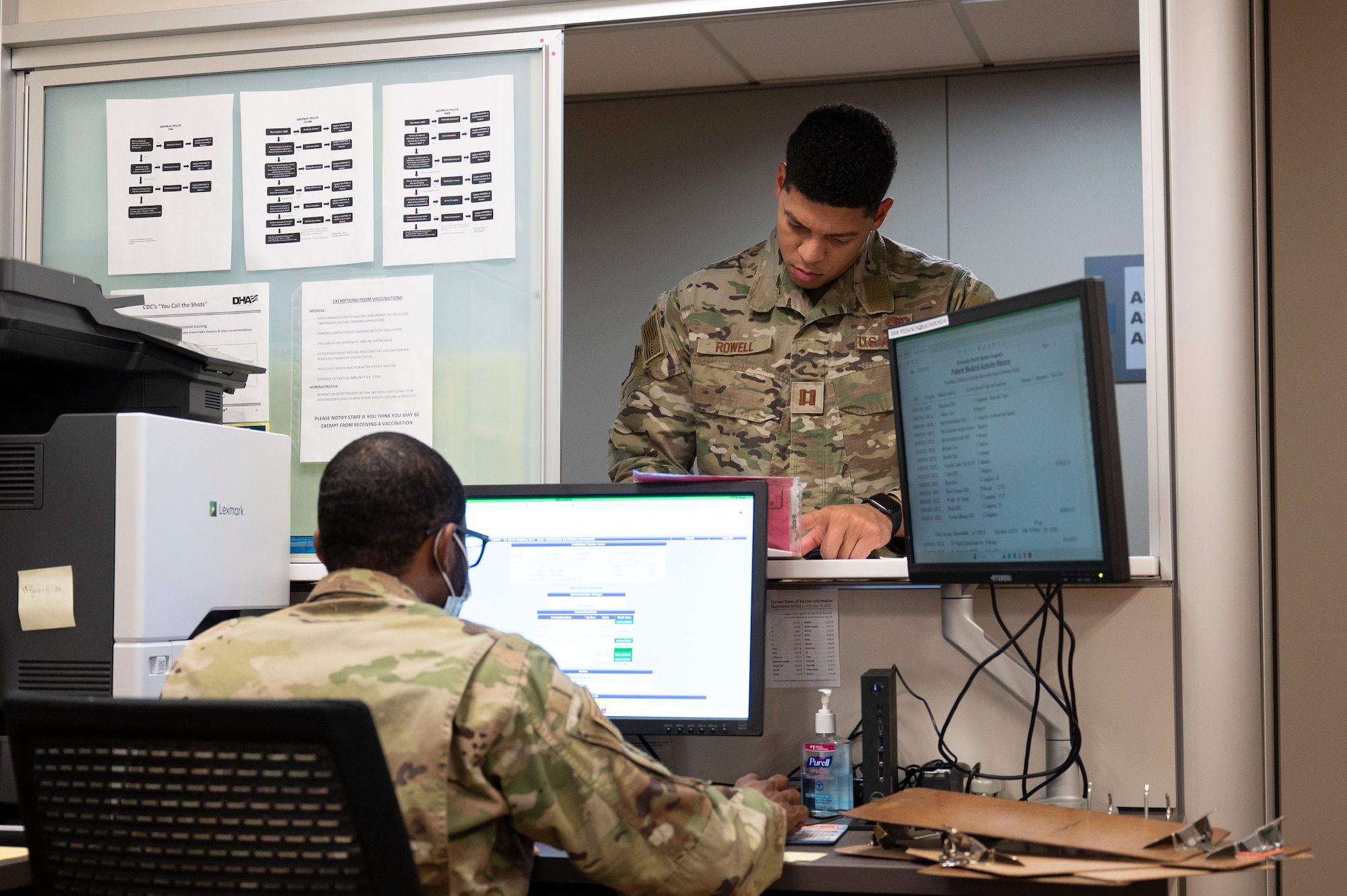 a man sits at a computer as a patient checks in