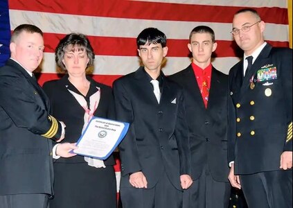 Former USS Hyman G. Rickover (SSN 795) Commanding Officer Cmdr. Troy Mung (left) presents a Certificate of Appreciation to Christine Greenough, wife of then Command Master Chief (CMDCM) and Rickover Chief of the Boat Larry G. Greenough (far right) at his retirement on Dec. 7, 2007. Greenough, now Norfolk Naval Shipyard’s USS New Hampshire’s (SSN 778) Assistant Project Superintendent, retired from the Navy in 2007 after 24 years of faithful service. Also pictured are Greenough’s sons, Larry J. (center), and Nicholas.