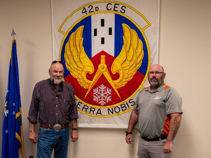 ames Wilson, 42nd Civil Engineering Squadron operation contracting officer’s representative and Robert Kiddy, 42nd CES operation flight chief pose in front of the 42nd CES banner at Maxwell Air Force Base, Alabama, April 4,2025.