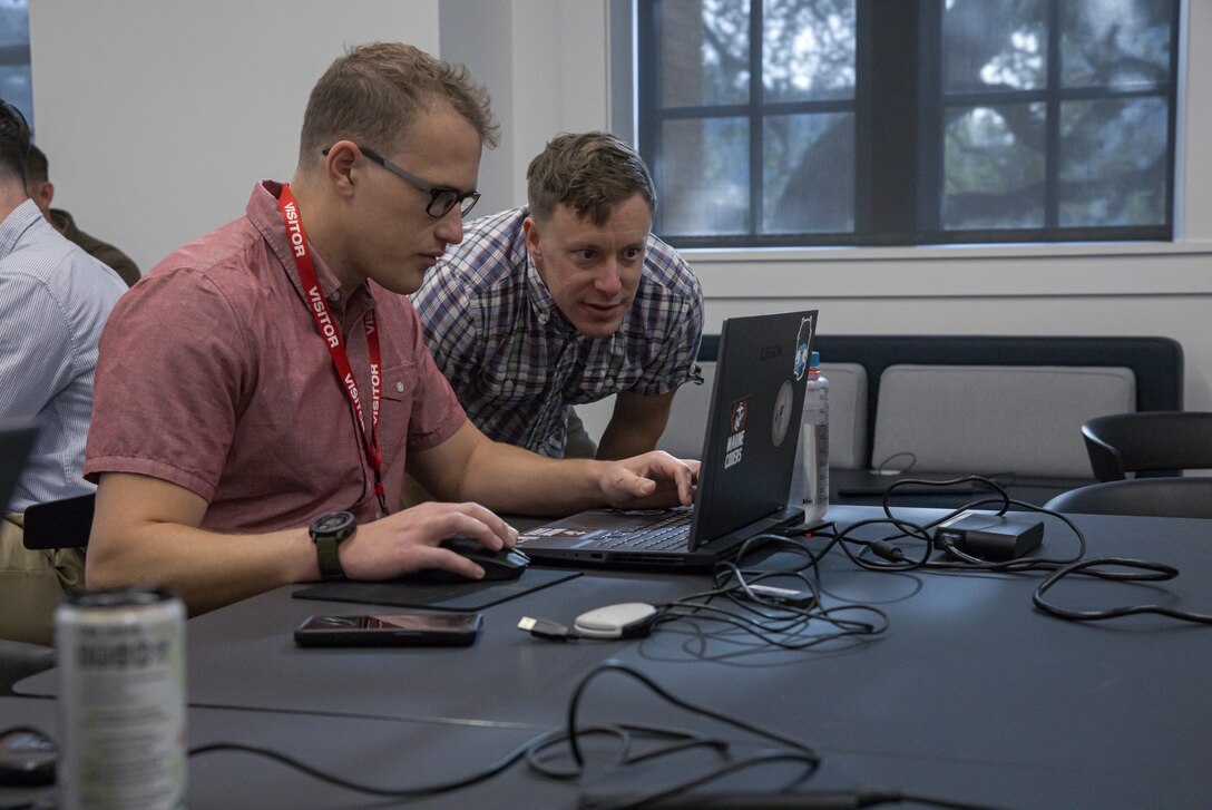 U.S. Marine Corps Maj. David McGee, right, and Capt. Geofforey Lindsell, left, both assigned to the Marine Innovation Unit (MIU), Marine Forces Reserve, interpret analytics from the Augmented Reconnaissance and Estimate of the Situation (ARES) software being created at the Marine Corps Software Factory (MCSWF) in Austin, Texas, 17 - 29 March, 2025. MIU Marines are assisting MCSWF in the development and production of software solutions that address critical needs for the Marine Corps, including an update to ARES that predicts helicopter landing zones based on topographical data. MIU is a Selected Marine Corps Reserve unit headquartered in Newburgh, N.Y. that accelerates the development and adoption of advanced capabilities across the Marine Corps. (U.S. Marine Corps photo by Cpl. Orion Stpierre)