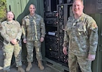 Air Force personnel pose in front of a crate containing WMD response equipment.