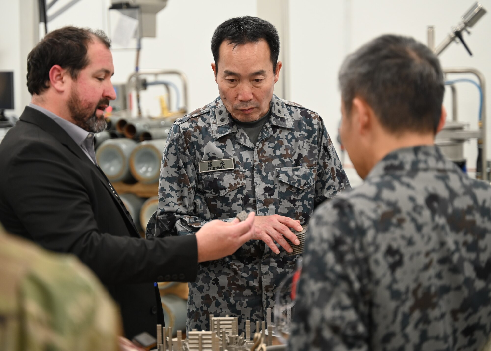 Two men observe a piece of equipment