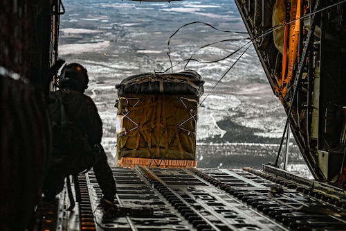 A loadmaster, assigned to the 61st Airlift Squadron, watches a container delivery system exit a C-130J Super Hercules aircraft during the Joint Pacific Multinational Readiness Center (JPMRC) 25-02 exercise at Joint Base Elmendorf-Richardson, Alaska, Jan. 19, 2025. As the installation’s host unit, the 19th Airlift Wing provides rapid global mobility and agile combat support, operating the C-130J Super Hercules aircraft to transport personnel, equipment and supplies into austere locations.