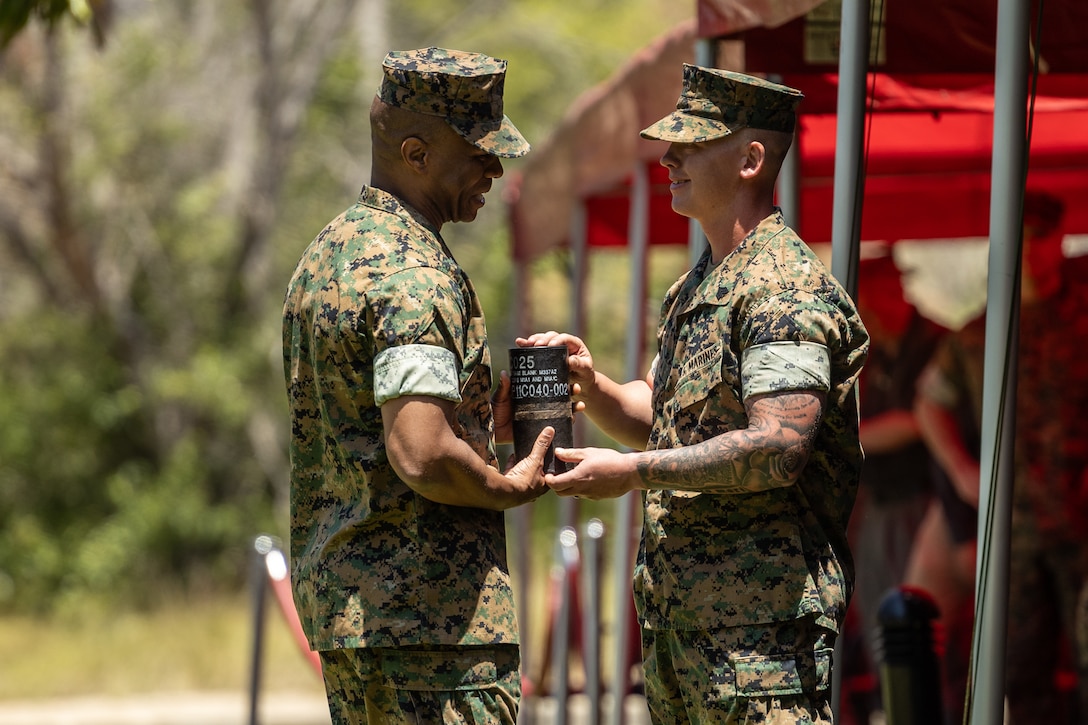 U.S. Marine Corps Brig. Gen. Nick I. Brown, left, the commanding general of Marine Corps Installations West Marine Corps Base Camp Pendleton, receives an M119 105 mm howitzer casing during a change of command ceremony at MCB Camp Pendleton, Calif., June 27, 2024. The casing was presented to Brown by the 11th Marine Regiment, 1st Marine Division to commemorate his first ceremonial gun salute and assumption of command as a general officer. (U.S. Marine Corps photo by Lance Cpl. Mhecaela J. Watts)
