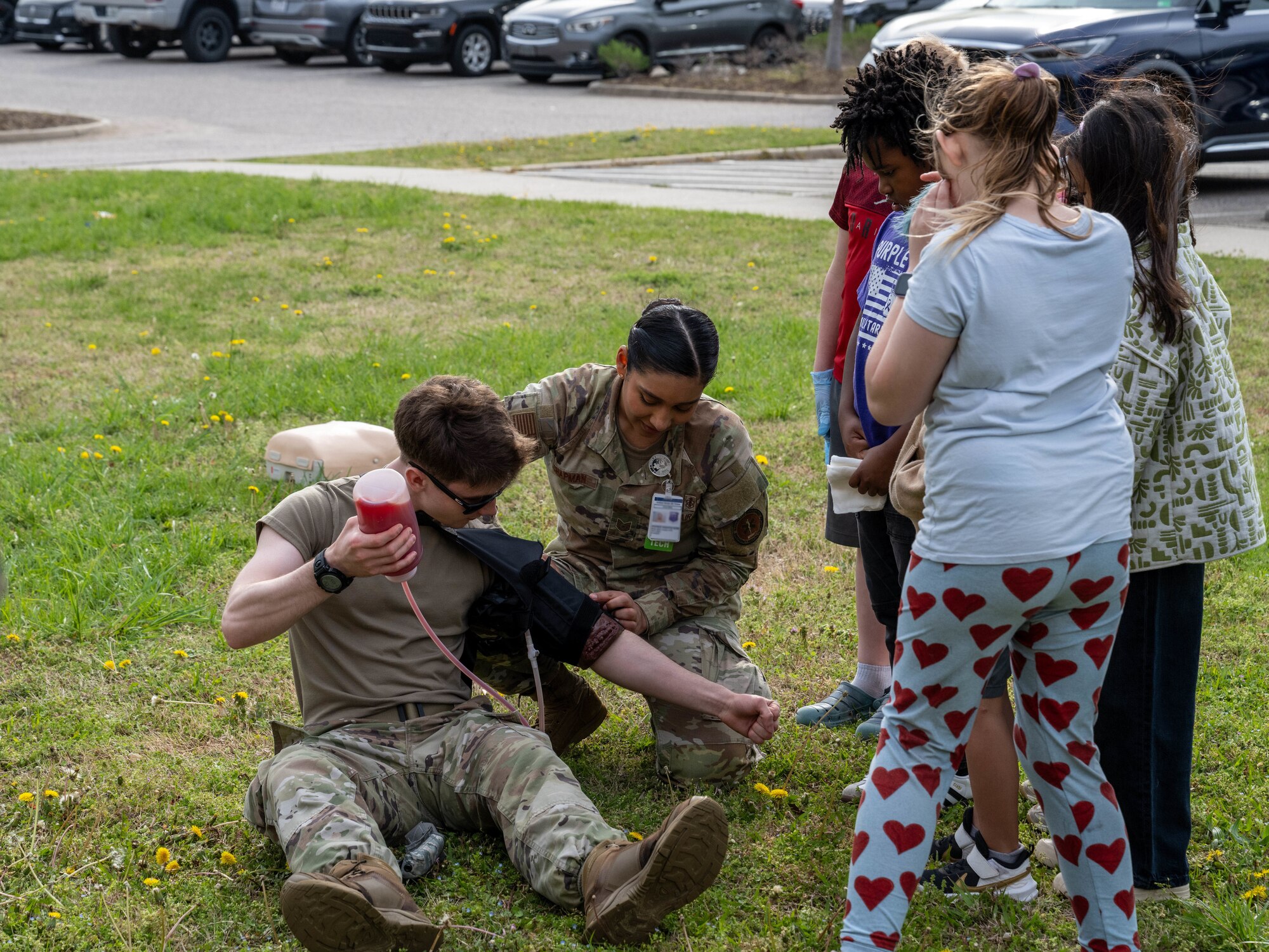 Two uniformed members use a tourniquet