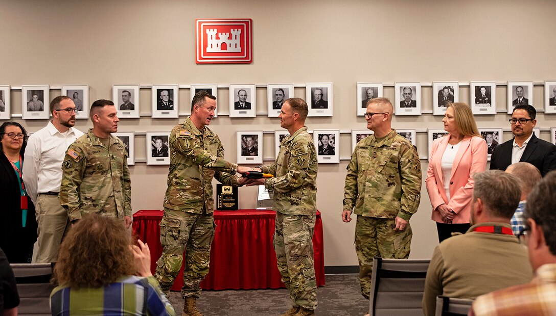 Col. Matthew Parker, (4th from left) deputy commander, Army Combat Readiness Center, formally presents the Army Safety and Occupational Health Star flag to Lt. Col. Matthew Miller, commander, Albuquerque District, during a ceremony at the district’s headquarters, April 1, 2025. (l-r): Cecilia Horner, chief, Engineering and Construction Division, Albuquerque District; Jacob Pauley, deputy district engineer, Albuquerque District; USACE Command Sgt. Maj. Douglas Galick; Col. Parker; Lt. Col. Miller; Col. James Handura, commander, USACE-South Pacific Division; Tracy Wolf chief, Safety Office, Albuquerque District; and Anthony Cardona safety and occupational health specialist, Albuquerque District.