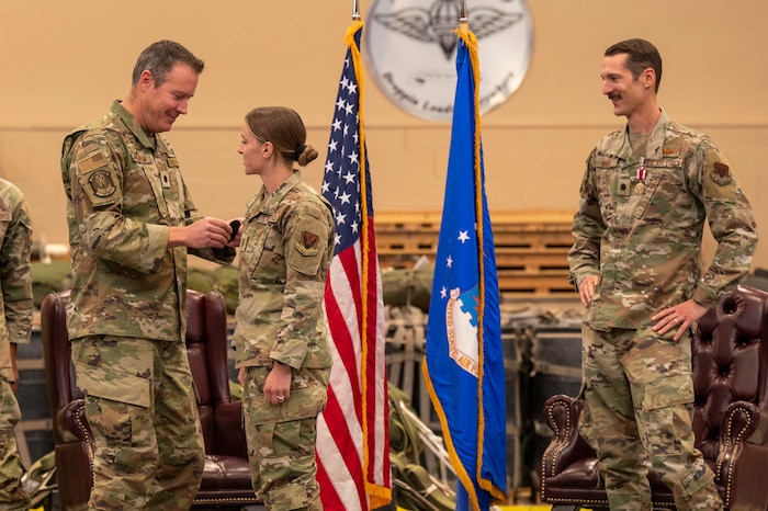 U.S. Air Force Lt. Col. Paul Sheehey, 563rd Operations Support Squadron commander, left, places a 563rd OSS patch on 1st Lt. Samantha Lolo, weather flight commander, center, after Lt. Col. Aaron Knight, former 355th OSS commander, removed her 355th OSS patch during the 355th OSS inactivation ceremony at Davis-Monthan Air Force Base, Arizona, April 3, 2025. The repatching symbolized the transfer of the flights from the 355th OSS to the 563rd OSS.