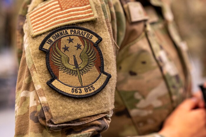 A U.S. Airman dons a 563rd Operations Support Squadron patch that they received during a repatching at the 355th OSS inactivation ceremony at Davis-Monthan Air Force Base, Arizona, April 3, 2025. Upon its inactivation, the 355th OSS flights transferred to the 563rd OSS.