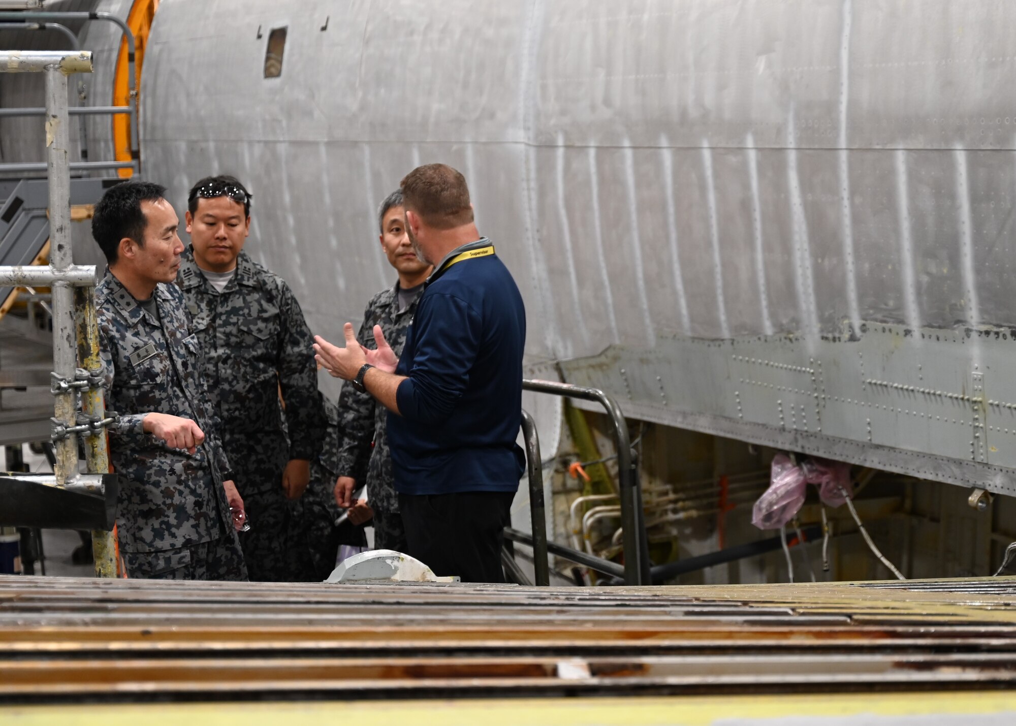 People standing near aircraft listening to presentation