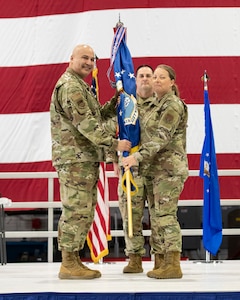 Chief Master Sgt. Andrea Young, 932nd Airlift Wing incoming command chief, receives the 932nd AW guidon from Col. Jeffrey Smith, 932nd AW commander, accepting her duty as 932nd AW command chief during the Change of Responsibility ceremony at Scott Air Force Base, Illinois, April 5, 2025. (U.S. Air Force photo by Staff Sgt. Brooke Spenner)