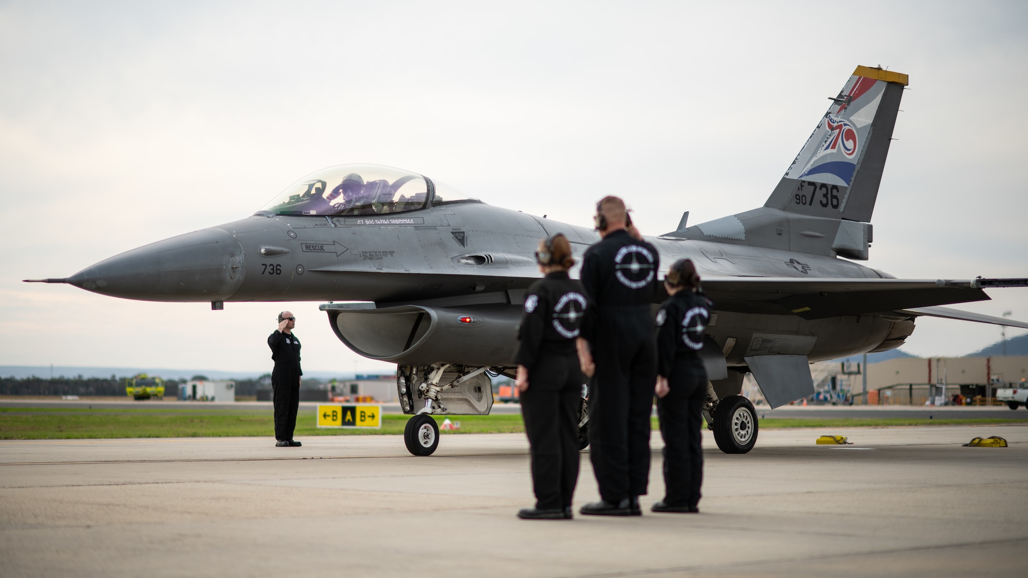 Fighter jet taxies past a demonstration team formation