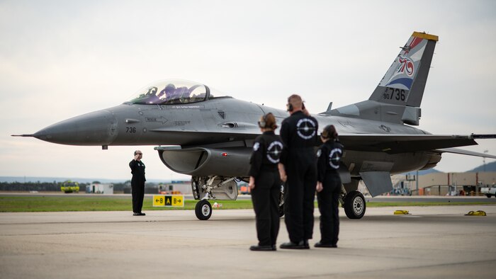 Fighter jet taxies past a demonstration team formation