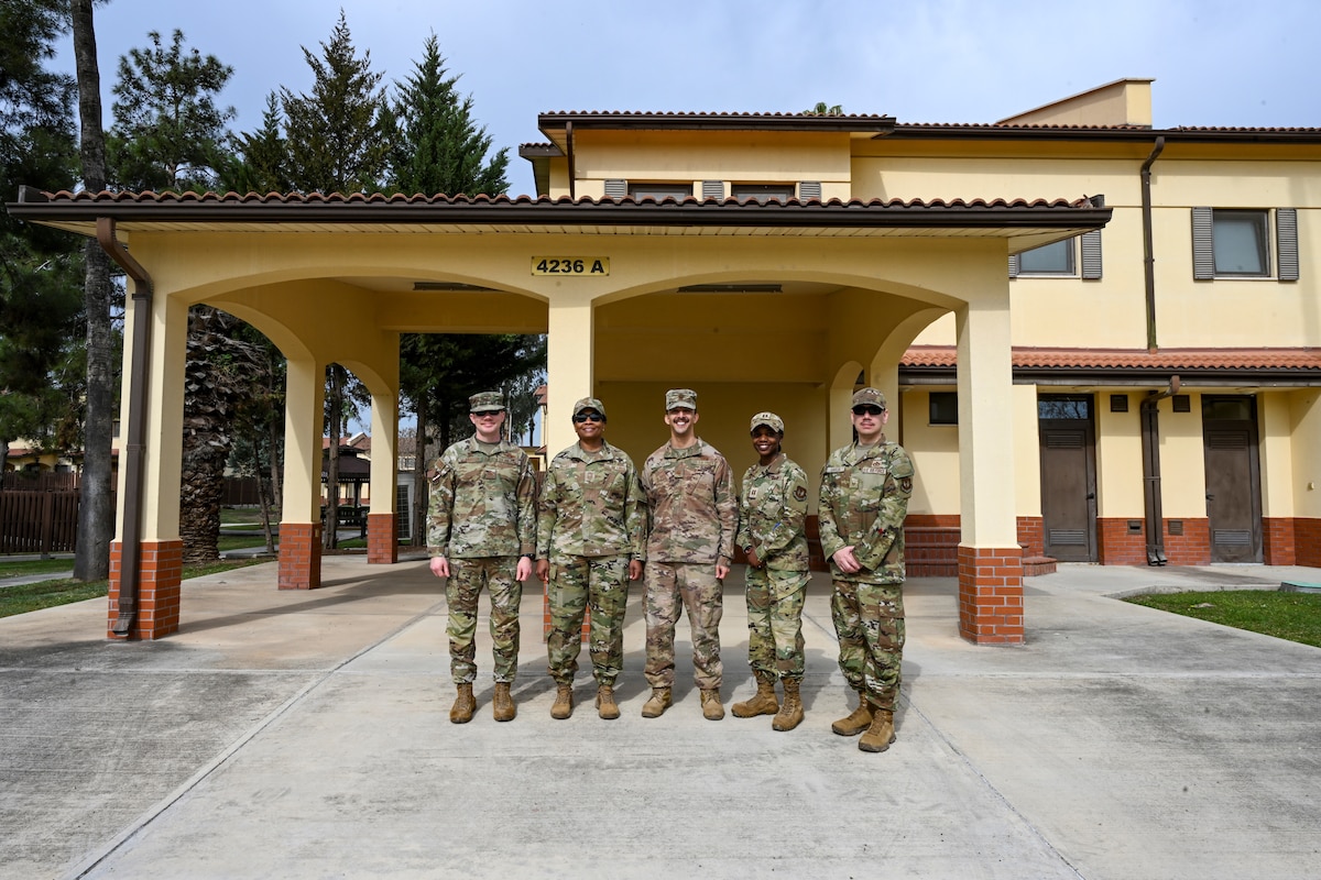 Leadership from the 39th Air Base Wing pose for a photo in front of base housing newly designated for accompanied dependents at Incirlik Air Base, Türkiye, March 18, 2025. The Department of Defense has approved updates to overseas tour lengths for military and civilian personnel assigned to permanent duty locations in Türkiye. Under the revised policy, inbound personnel will have the option to select either a 24-month accompanied tour or a 12-month unaccompanied tour. For personnel assigned to Incirlik Air Base, accompanied dependents must be 18 years of age or older. (U.S. Air Force photo by Senior Airman Haiden Morris)