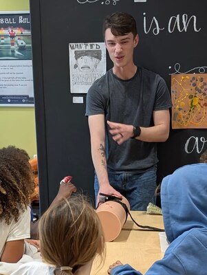 SIGONELLA, Italy. (April 2, 2025) Hospital Corpsman 2nd Class Connor Hepker, assigned to U.S. Navy Medicine Readiness and Training Command Sigonella, teaches a group of young children how to help an injured friend during a recent Stop the Bleed course, April 2, 2025. Stop the Bleed is a Department of Defense (DoD) program that arms anyone who might see someone get injured with the life-saving skills to control hemorrhage while waiting for help to arrive. With these skills, the students can feel confident helping a friend out after cat bites, playground injuries, or zombie attacks! (U.S. Navy courtesy photo).