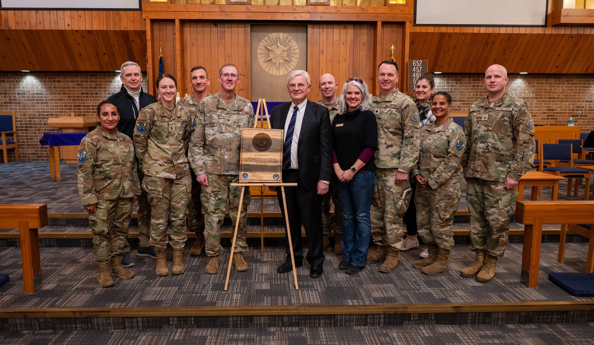 A group of military members surrounding a Liberty Tree plaque
